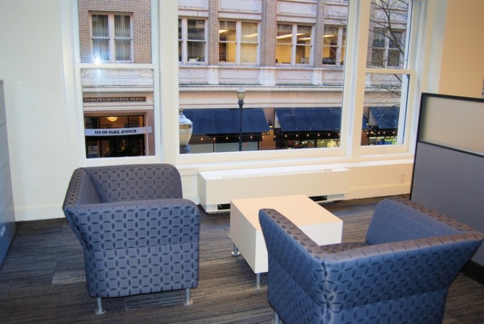 Commercial guest seating area with blue arm chairs and white low profile table
