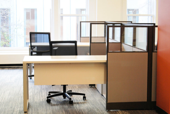 Semi-private work stations with glass panel stackers and desks with modesty panels