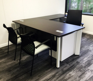 L shaped dark wood top executive desk with guest seating