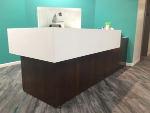 Dark finish reception desk with white transaction top