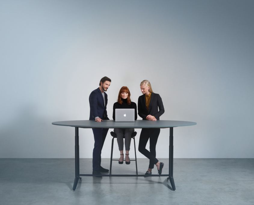 collaborative standing height table with employees working together
