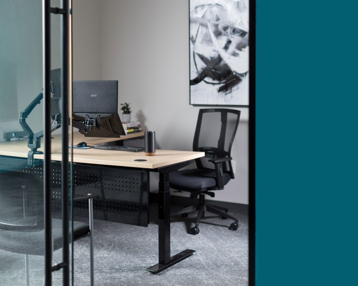 Clear Design private office with height adjustable desk in natural wood with black base and task chair