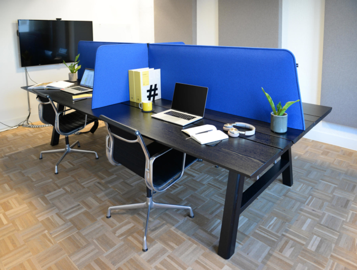 Buzzi Space semi-private black desks with bright blue table top partitions
