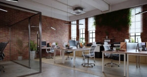 A neat and modern-looking small office with multiple desks. Natural light floods the space, making it look more inviting and open.