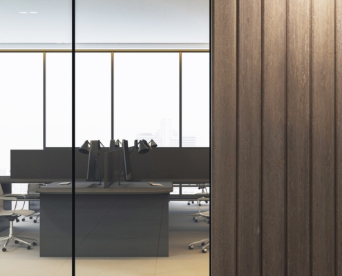 An office interior featuring glass walls, wooden panel accents, and minimalist workstations in a high-rise building.