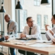 A diverse group of businesspeople talking together in a modern company conference table around an office table.