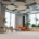 Contemporary workspace relaxation area featuring chairs, sofa, greenery, and circular sound-absorbing ceiling panels.